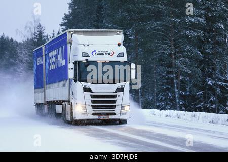 White Scania R500 Truck tire une remorque de fret sur l'autoroute glacée et enneigée dans les chutes de neige hivernales. Salo, Finlande. 18 janvier 2019. Banque D'Images