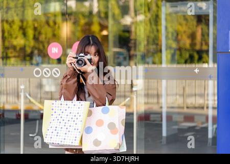 La femme shopping aime la mode de vie tient des sacs des ventes du Black friday Mall, les gens la regardent Banque D'Images