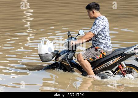 BANGKOK, THAÏLANDE, nov 09 2025, Une moto roule dans une rue inondée, Thaïlande Banque D'Images
