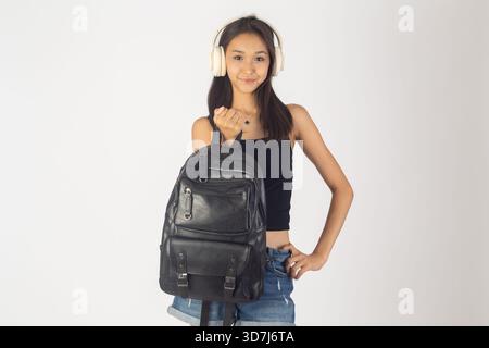 Une femme est debout et tient un sac à dos noir Banque D'Images