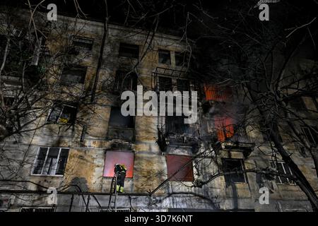Un pompier monte l’échelle dans un immeuble résidentiel en feu qui a été touché par un drone russe, Zaporizhzhia, Ukraine, le 25 novembre 2025. Mardi soir, le 25 novembre, Zaporizhzhia a été attaqué par des drones russes. La ville a subi d'importants dommages aux infrastructures de logement civil. Plusieurs incendies de grande ampleur ont été signalés. Dix-neuf personnes ont été blessées dans l'attaque. (Photo de Dmytro Smolienko/Ukrinform) Banque D'Images