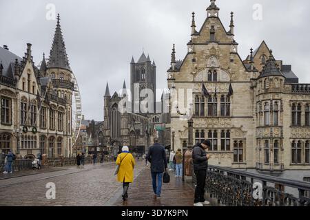 Bâtiments de style médiéval traditionnel et bâtiment de la cathédrale Saint-Bavon dans une rue piétonne à Gand en Belgique. Photo prise un jour nuageux et rarineux Banque D'Images