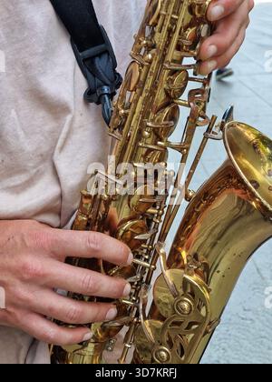 Gros plan image verticale de la main d'un musicien jouant des notes sur un saxophone de couleur dorée. Banque D'Images