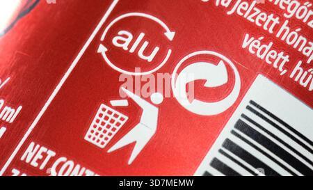 Icônes de recyclage sur une boîte en aluminium rouge, logo alu avec des flèches circulaires, tidyman jetant de la litière, symboles près du code à barres, étiquetage de durabilité sur l'emballage Banque D'Images