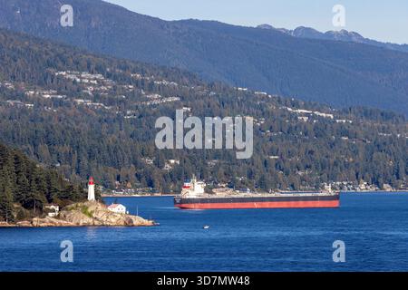 Phare de point Atkinson et porte-conteneurs à Burrard Inlet, West Vancouver, Colombie-Britannique, Canada Banque D'Images