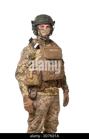 Portrait de trois quarts d'un soldat portant camouflage, casque et gilet tactique, photographié sur fond blanc pour usage éditorial. Banque D'Images