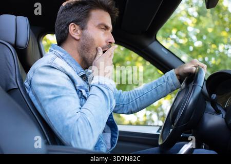 portrait fatigué homme drôle bâillant dans la voiture Banque D'Images