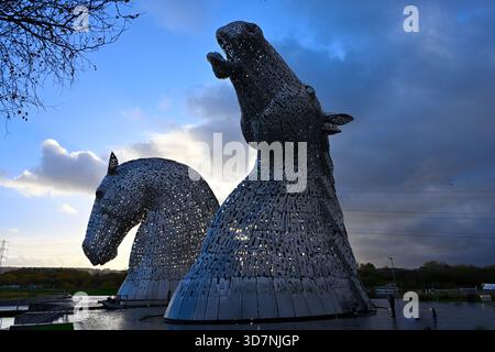 Les Kelpies, œuvre d'art public en acier de deux énormes têtes de chevaux par Andy Scott à Helix Park, en automne soir lumière Écosse novembre Banque D'Images