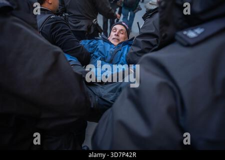 Londres, Angleterre, Royaume-Uni. (26 novembre 2025) les manifestants de Palestine action ont été de nouveau arrêtés en vertu de la loi sur le terrorisme pour avoir tendu des pancartes de soutien au groupe interdit. L’action de masse en dehors des cours royales de Justice a été coordonnée pour coïncider avec la contestation judiciaire de l’action proscription de la Palestine qui commence cette semaine. Crédit photo : Lab Mo/ALAMY LIVE NEWS Banque D'Images