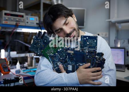 Un homme tient un grand nombre de divers composants électroniques étroitement Banque D'Images