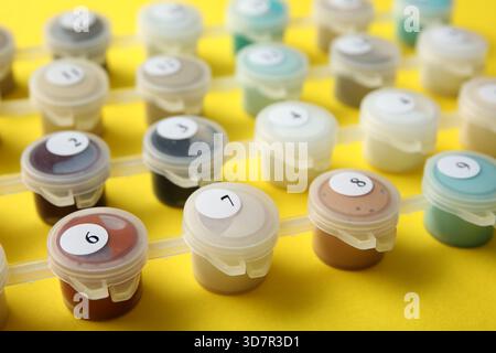 Peintures pour peindre par des chiffres sur fond jaune, gros plan Banque D'Images