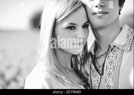 Couple sur le costume traditionnel au champ de fleurs jaunes Banque D'Images