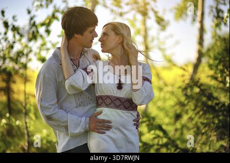 Couple sur le costume traditionnel au champ de fleurs jaunes Banque D'Images