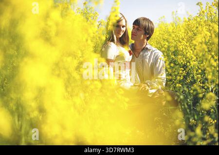 Couple sur le costume traditionnel au champ de fleurs jaunes Banque D'Images