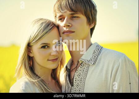 Couple sur le costume traditionnel au champ de fleurs jaunes Banque D'Images