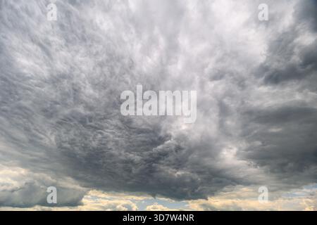Une vue captivante d'un ciel sombre et couvert rempli de nuages tourbillonnants, parfait pour les projets atmosphériques. Banque D'Images