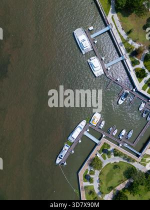 Le bateau est amarré à une marina. Il y a plusieurs bateaux dans l'eau. La marina est située près d'un parc Banque D'Images