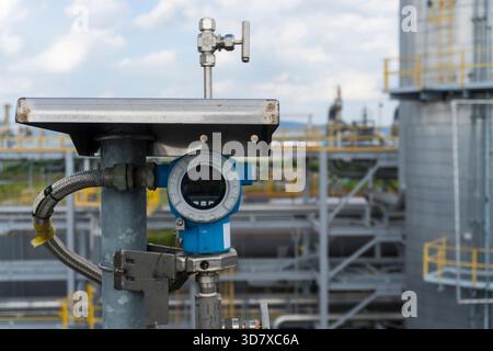 Vue rapprochée d'un transmetteur de pression industriel installé dans une usine pétrochimique, utilisé pour la surveillance et le contrôle de processus. Banque D'Images