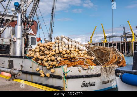Grande pile de filets de pêche commerciale et de flotteurs jaunes sur le pont du navire Barbara à un quai à Homer, en Alaska. Banque D'Images
