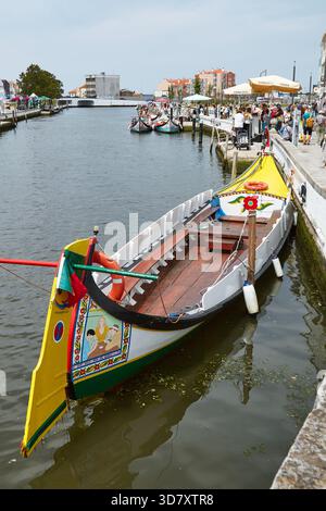 Aveiro, Portugal - 14 juin 2025 : des bateaux colorés de moliceiros sont amarrés le long du pittoresque canal Aveiro, entouré par une architecture urbaine dynamique et liv Banque D'Images