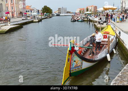 Aveiro, Portugal - 14 juin 2025 : les bateaux Moliceiros sont amarrés le long du canal Aveiro, mettant en valeur l'architecture colorée et une atmosphère animée à Portug Banque D'Images