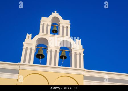 Une vue rapprochée des célèbres trois cloches de l'église catholique de la Dormition à Fira, face à un ciel bleu profond Banque D'Images