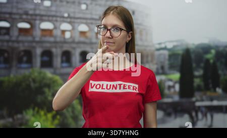 Femme bénévole se tient avec les mains sur les côtés à l'extérieur au milieu du colisée romain avec visage et cheveux visibles ; sérénité. Banque D'Images