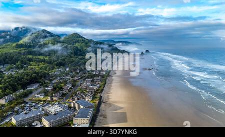 Prise aérienne au-dessus de Cannon Beach, Oregon, par un matin brumeux, avec Haystack Rock et des paysages côtiers moroses Banque D'Images