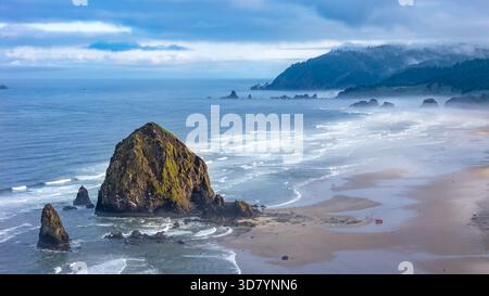 Prise aérienne au-dessus de Cannon Beach, Oregon, par un matin brumeux, avec Haystack Rock et des paysages côtiers moroses Banque D'Images