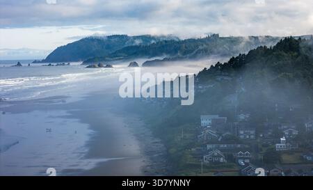 Prise aérienne au-dessus de Cannon Beach, Oregon, par un matin brumeux, avec Haystack Rock et des paysages côtiers moroses Banque D'Images