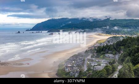 Prise aérienne au-dessus de Cannon Beach, Oregon, par un matin brumeux, avec Haystack Rock et des paysages côtiers moroses Banque D'Images