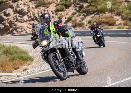Motocycliste prenant un virage serré par un dimanche ensoleillé dans le port de Navalmoral, dans la province d'Avila, en Espagne, au cours du mois d'août 2023 Banque D'Images