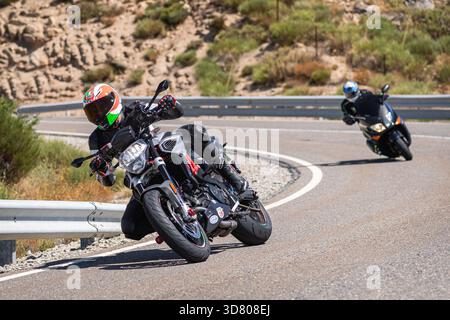 Motocycliste prenant un virage serré par un dimanche ensoleillé dans le port de Navalmoral, dans la province d'Avila, en Espagne, au cours du mois d'août 2023 Banque D'Images