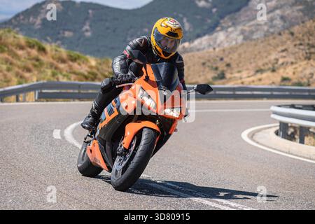 Motocycliste prenant un virage serré par un dimanche ensoleillé dans le port de Navalmoral, dans la province d'Avila, en Espagne, au cours du mois d'août 2023 Banque D'Images