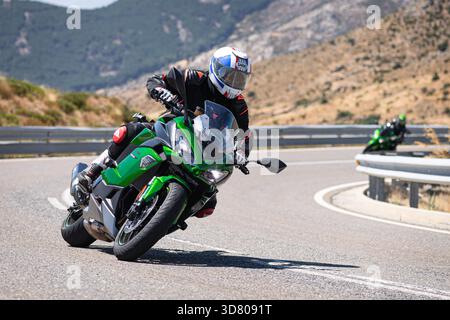 Motocycliste prenant un virage serré par un dimanche ensoleillé dans le port de Navalmoral, dans la province d'Avila, en Espagne, au cours du mois d'août 2023 Banque D'Images