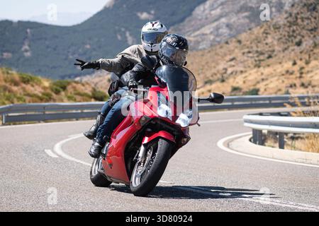 Motocycliste prenant un virage serré par un dimanche ensoleillé dans le port de Navalmoral, dans la province d'Avila, en Espagne, au cours du mois d'août 2023 Banque D'Images