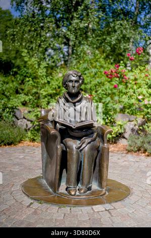 Titre : statue en bronze de l'auteur Astrid Lindgren lisant un livre, Junibacken, Banque D'Images