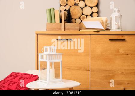 Lanterne de Noël avec bougie incandescente sur la table basse dans la salle de fête, gros plan Banque D'Images