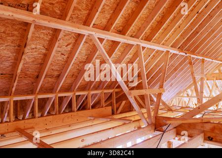 Les fermes de poutres en bois créent un toit solide dans le bâtiment en construction Banque D'Images