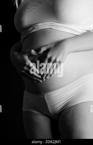 Image ombragée d'un ventre enceinte. Fabriqué dans un environnement studio sur fond noir avec un Canon 5D, pays-Bas Banque D'Images