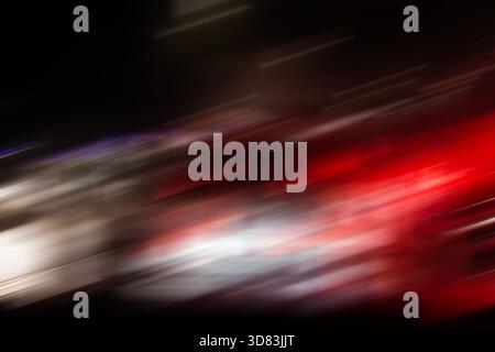 Un flou de mouvement abstrait de lumière rouge et blanche de voiture traîne la nuit, créant une sensation de vitesse et d'énergie élevée. Banque D'Images