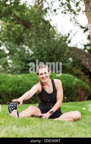 Femme en vêtements de sport noirs s'étirant Banque D'Images