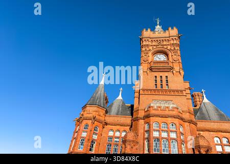 Détail du bâtiment victorien Pierhead dans la baie de Cardiff. Un bâtiment emblématique de style gothique en briques rouges, connu sous le nom de Welsh Big Ben, contre un blu clair Banque D'Images
