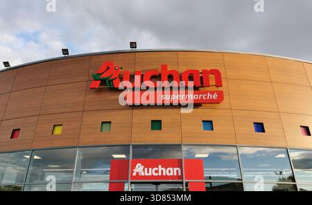 Vue extérieure du supermarché Auchan. Le bâtiment a une façade lambrissée avec des fenêtres carrées. France Banque D'Images