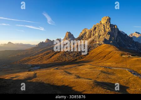 Sommets montagneux et prairies alpines baignés de lumière chaude lors d'un coucher de soleil d'automne Banque D'Images