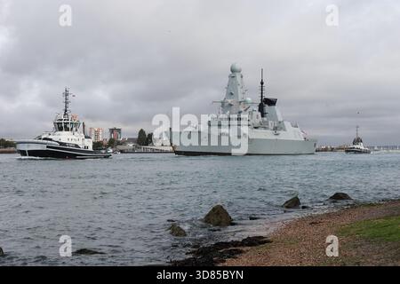 Les remorqueurs TEMPEST DE la base navale et l'escorte INDULGENTE du destroyer de défense aérienne type 45 de la Royal Navy Daring Class HMS DUNCAN (D37) hors du port Banque D'Images