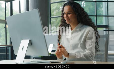 Positive hispanique femme d'affaires parlant appel vidéo dans le bureau souriant femme d'affaires joyeuse femme fille parler conférence chat virtuel ordinateur Banque D'Images