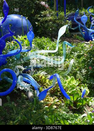 SEATTLE - APR 25, 2025 - sculptures en verre coloré en bleu et bleu clair, ressemblant à des plantes et des formes abstraites, se dressent de la végétation verte luxuriante dans un Banque D'Images