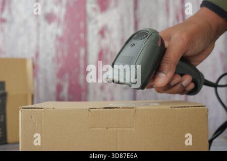 Lecture d'un code-barres sur une boîte en carton pour le suivi de l'inventaire Banque D'Images