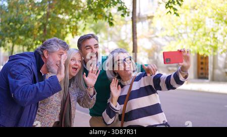 Couple senior prenant un selfie avec un smartphone à l'extérieur Banque D'Images